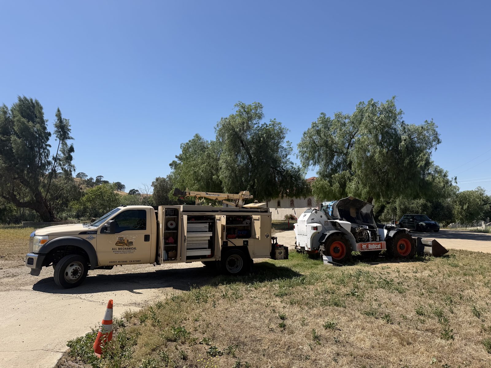 All Mechanical branded mobile service truck on-site with Bobcat skid steer in the Bay Area